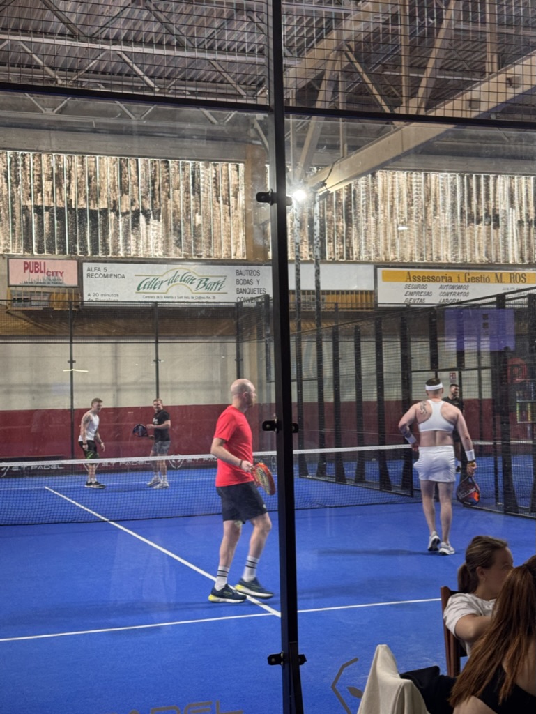 Stag party playing padel in fancy dress at night